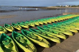 Image de kayaks prêts pour un départ de raid multisport sur une plage