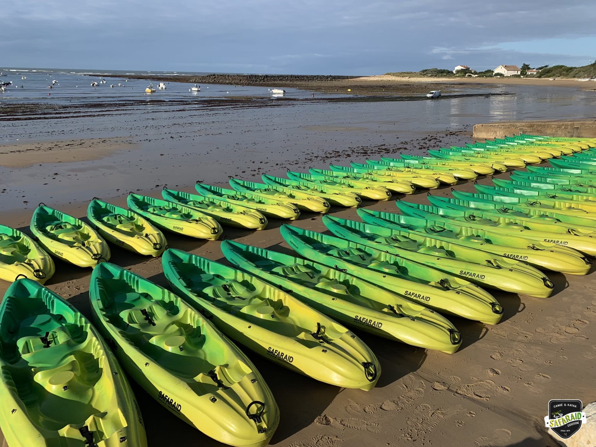 Image de kayaks prêts pour un départ de raid multisport sur une plage